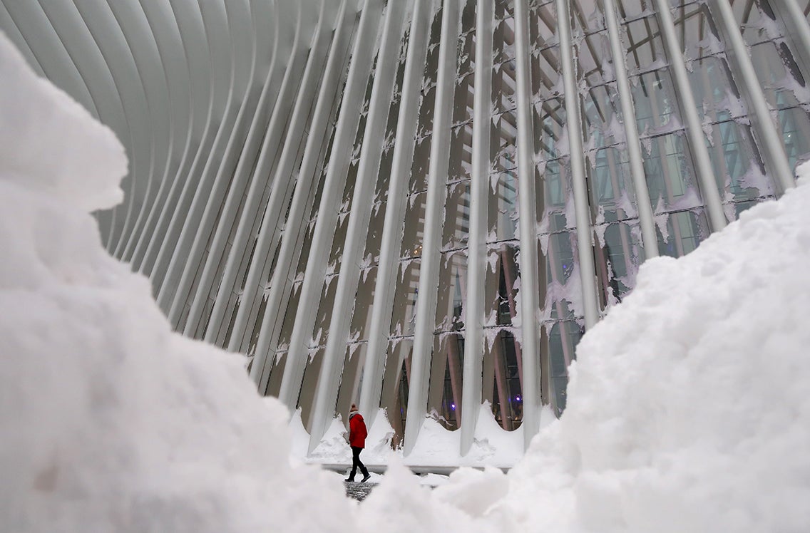 Un hombre camina fuera del centro de tránsito de Oculus en la ciudad de Nueva York durante una tormenta invernal de 